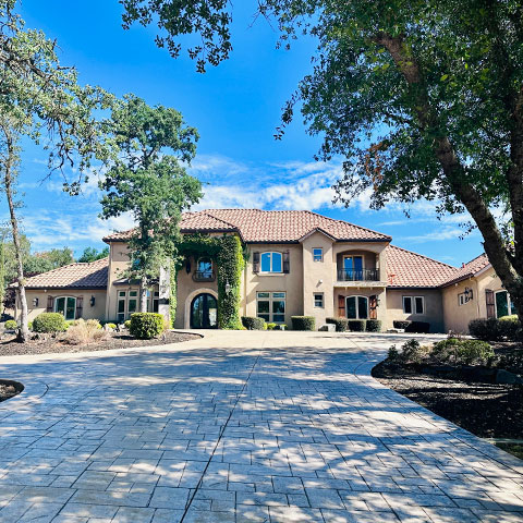 a beautiful mansion with a large shady driveway