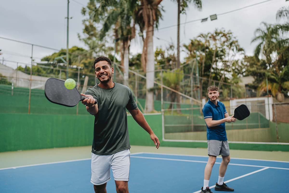 two men play pickleball