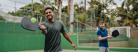 two men play pickleball